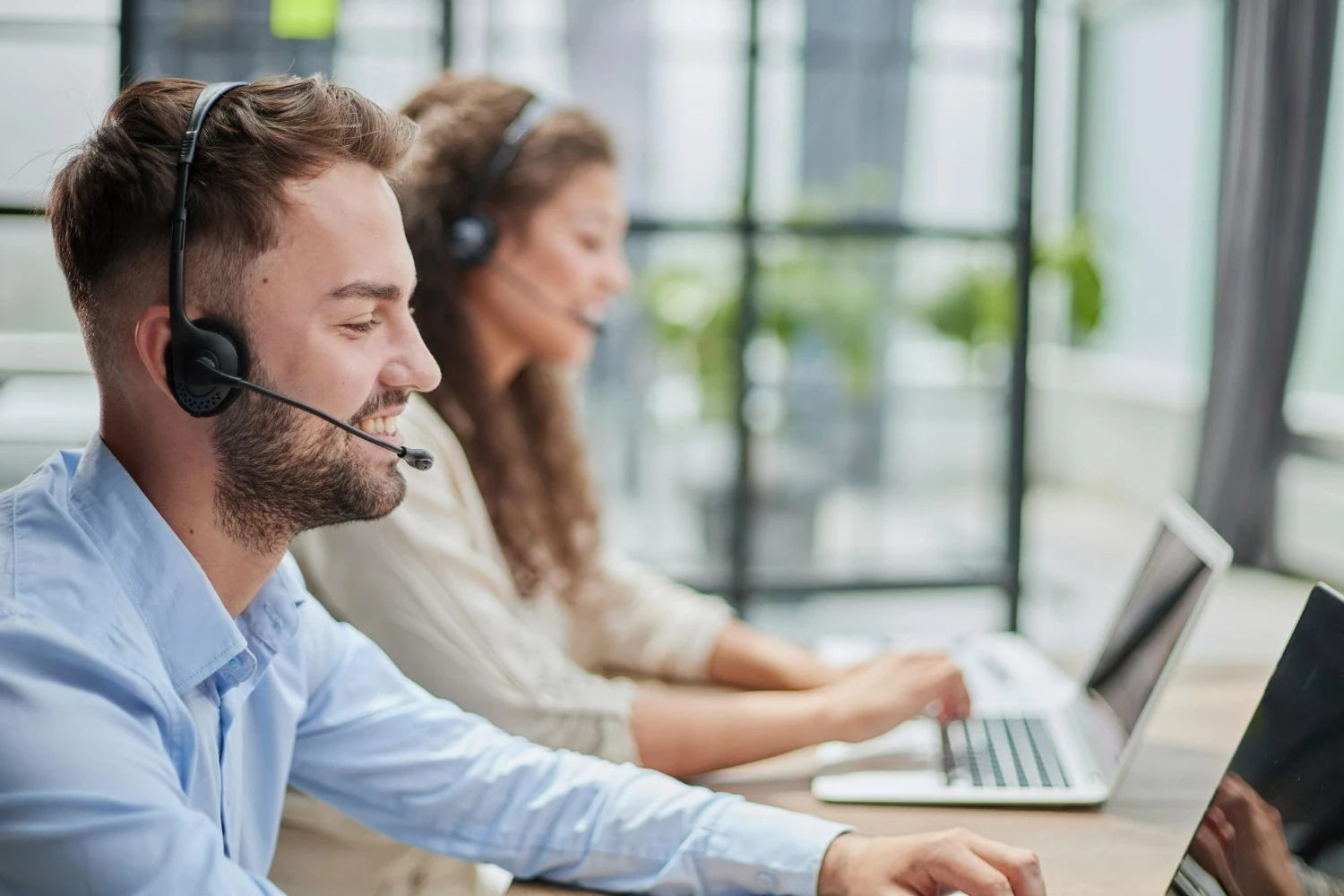 Salespeople with headsets talking to new customers