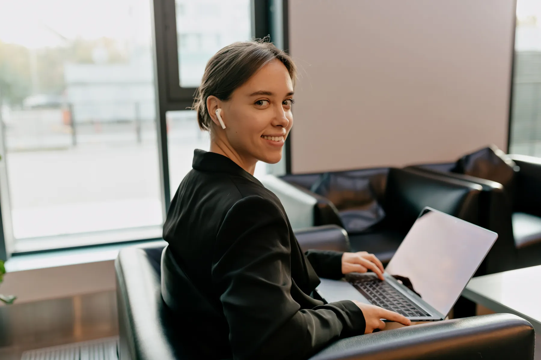 Sales development rep with a headset at a laptop in a bright office